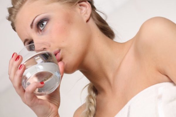 Девушка пьёт воду из стакана