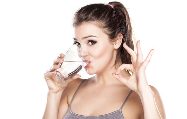 Девушка пьёт воду с перекисью из стакана