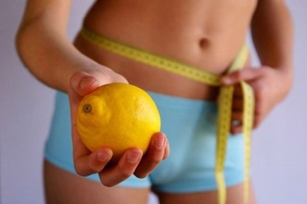 Юноша держит лимон — средство для похудения