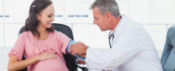 Врач измеряет давление беременной
